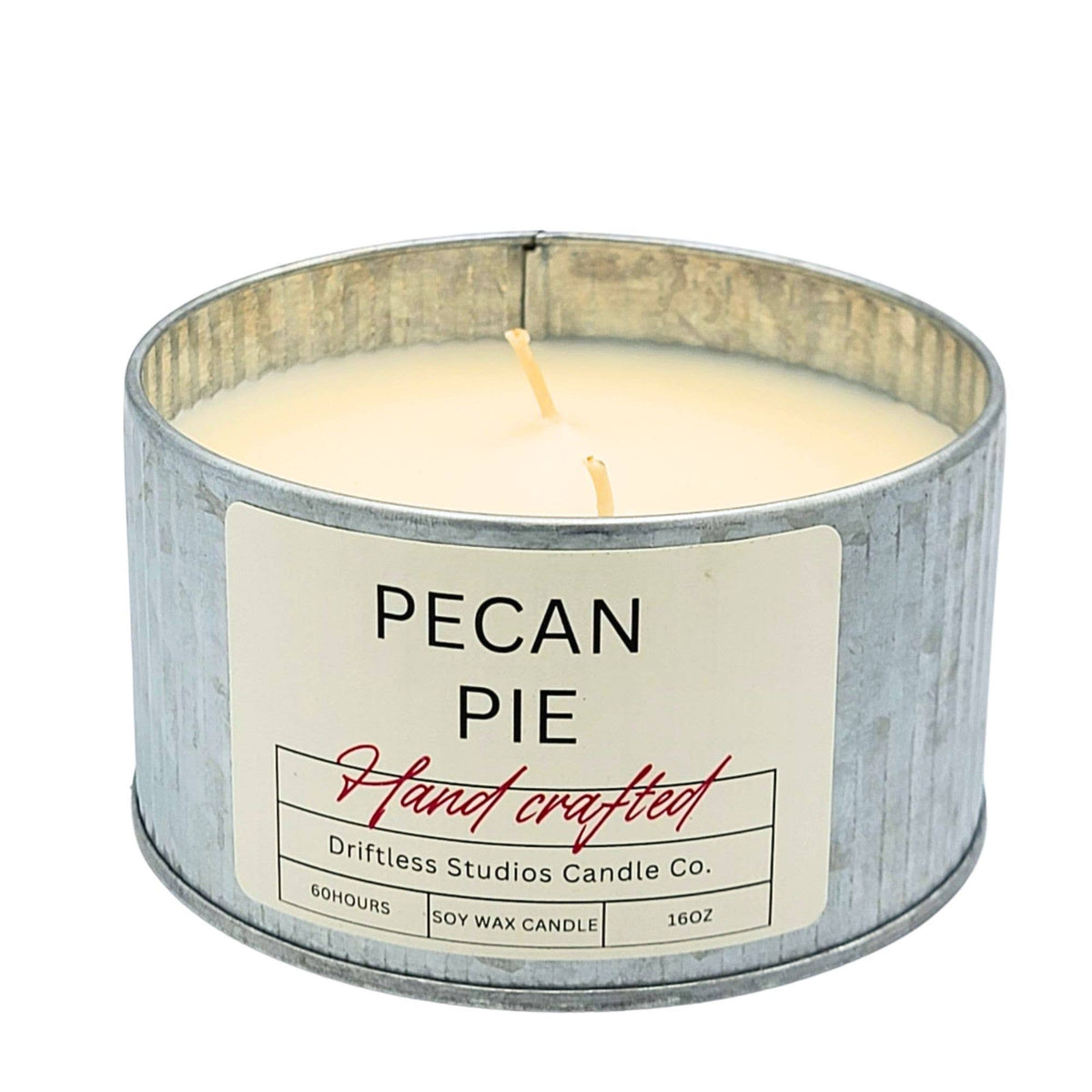 A metal tin candle with a white label reading 'PECAN PIE' and 'Hand crafted' by Driftless Studios Candle Co., shown on a white background.