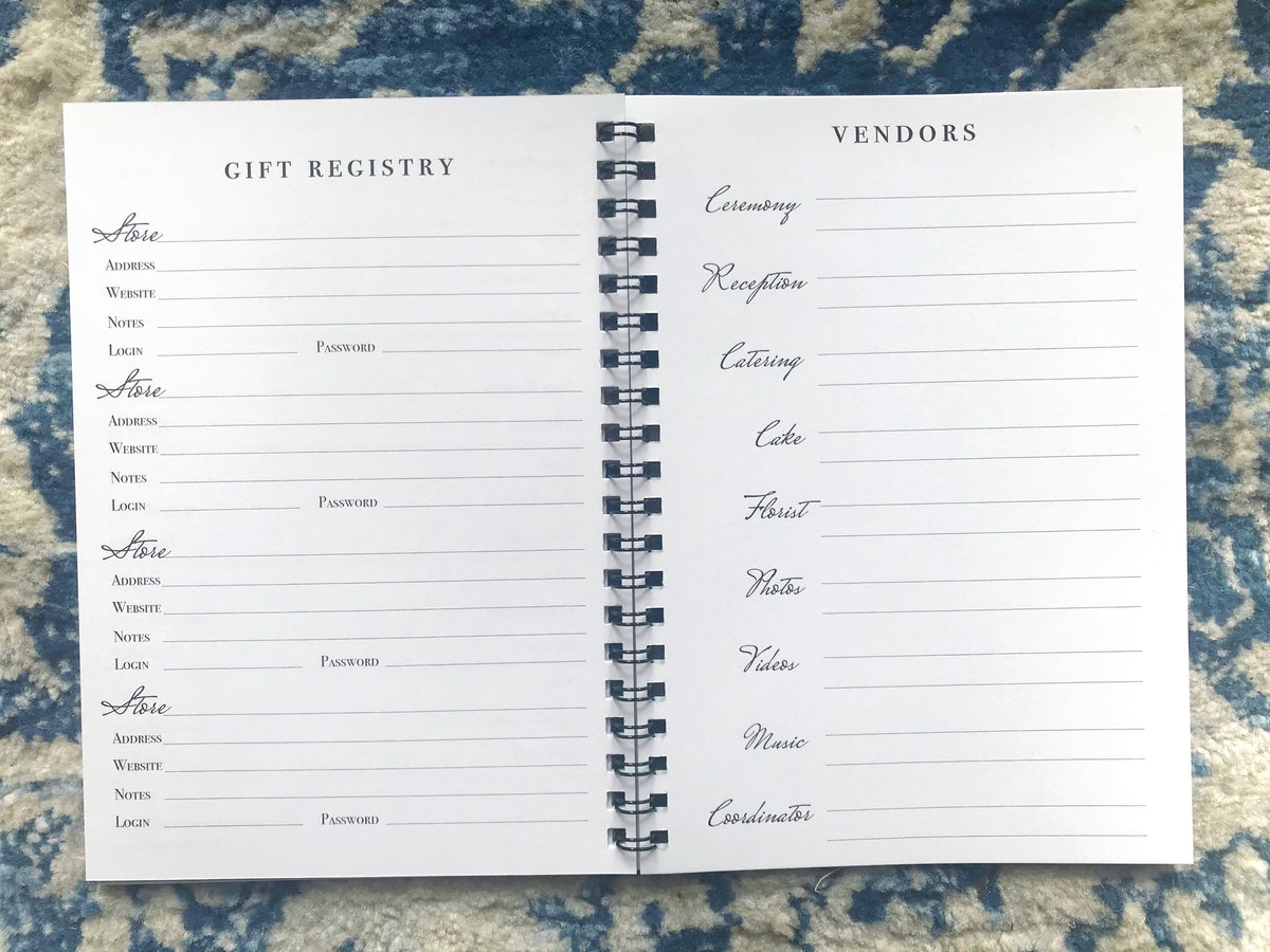 Open notebook with 'Gift Registry' and 'Vendors' pages on a textured surface.